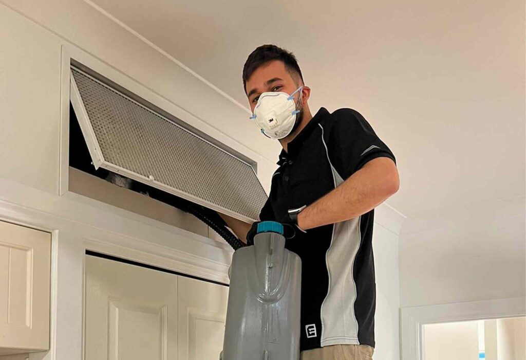 tech cleaning air duct in sydney wearing white mark and black tshirt